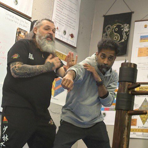 Two men practicing martial arts techniques indoors.